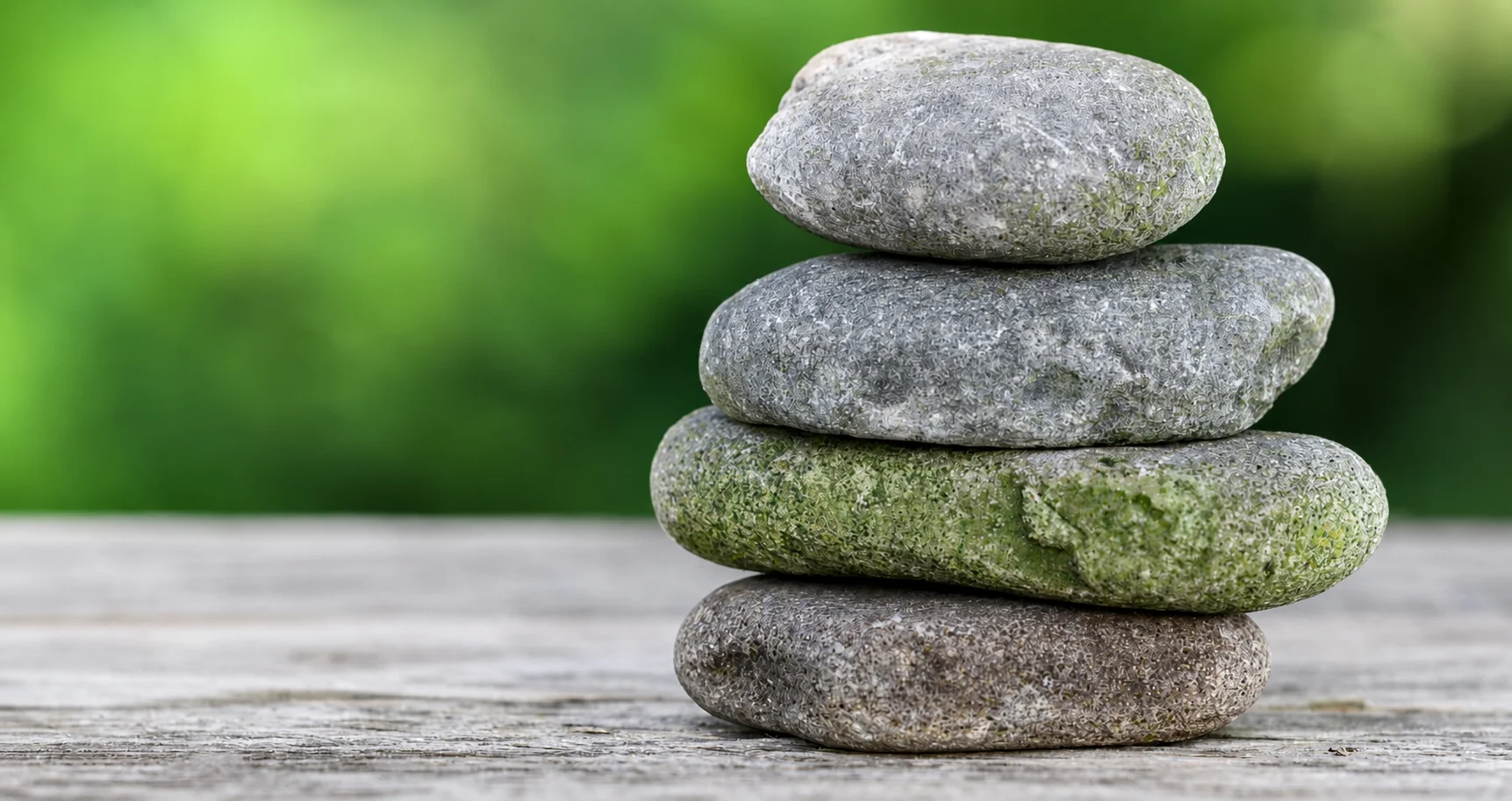 A balanced stack of natural stones in a green garden setting